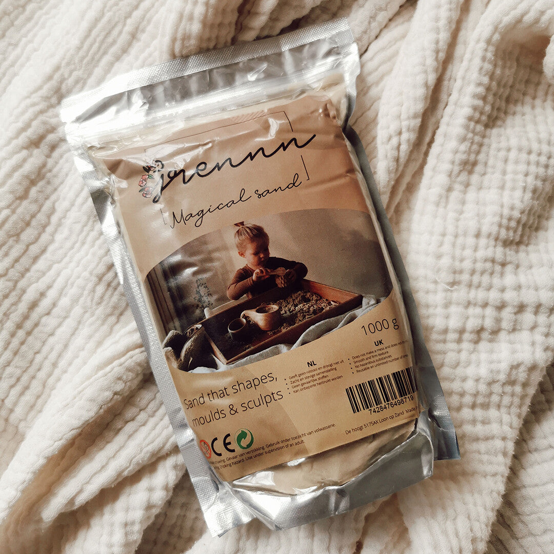 grennn kinetisch zand verpakking van 1 kg liggend op een witte deken.