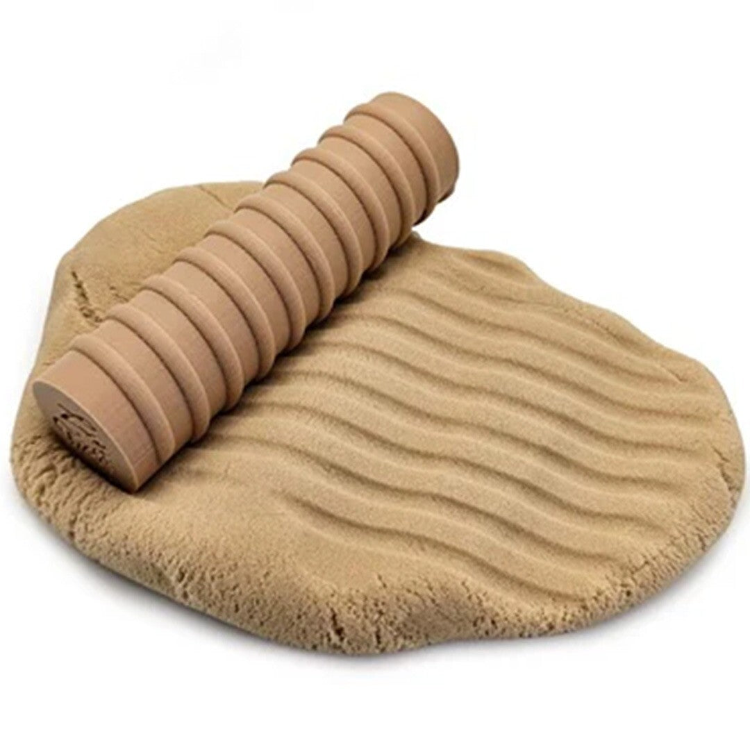 grennn houten roller met textuur op beige speelzand met golvende patronen.
