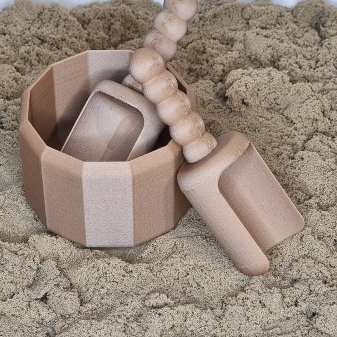 Grennn beige twaalfhoekig speelbakje met twee schepjes in zand.