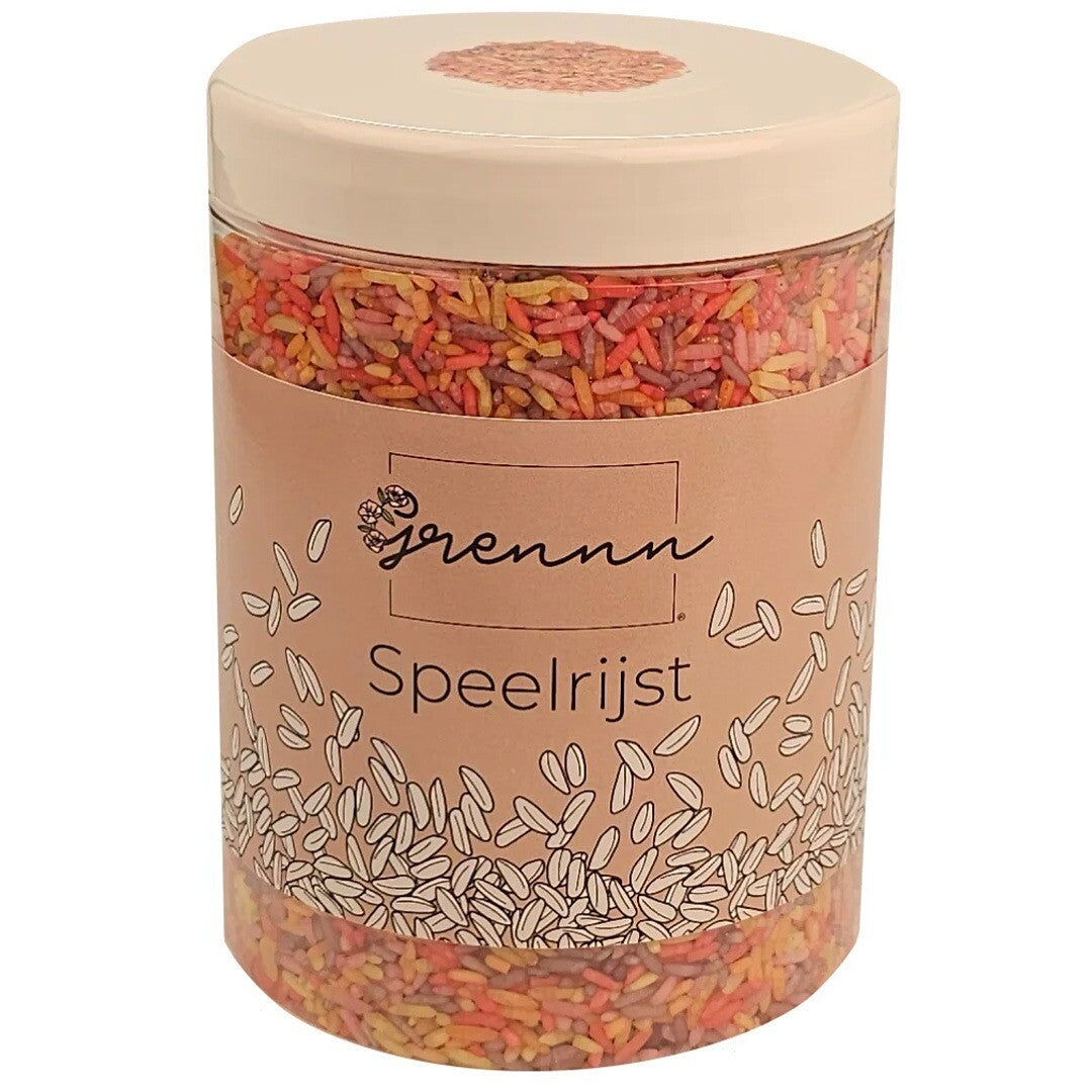 De verpakking van Grennn speelrijst fruit mix, een transparante pot met een bruin etiket en roze deksel.