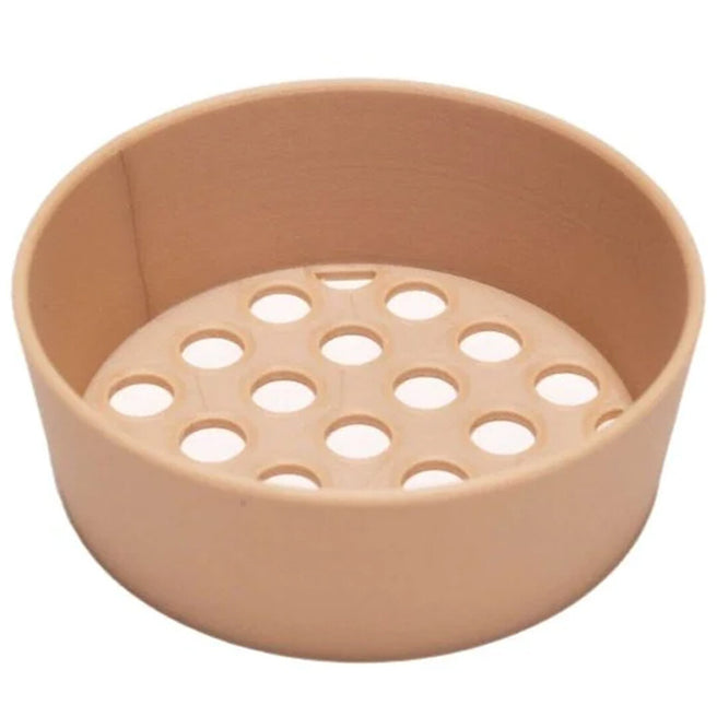 Grennn beige plastic zandbakzeef met gatenpatroon, schuin gefotografeerd.