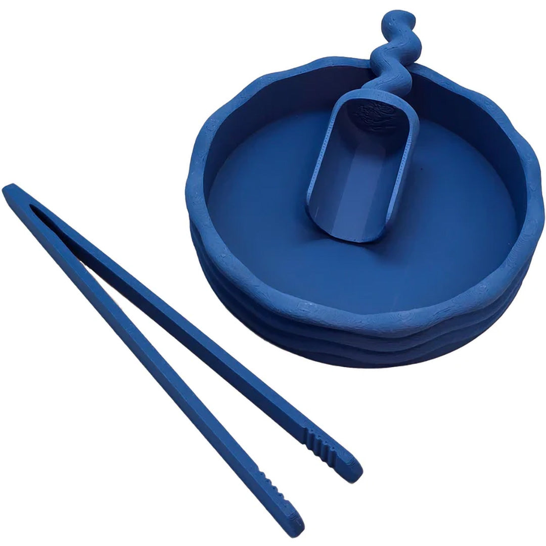 Een Grennn blauw pincet en een blauwe kom met schepje, sensorisch speelgoed, schuin gefotografeerd op een witte achtergrond.