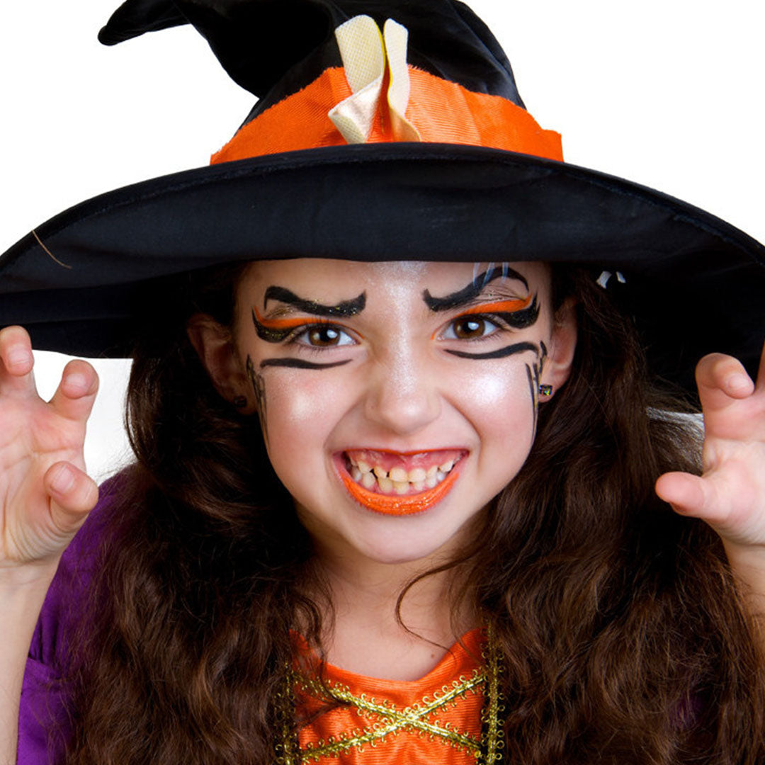 Meisje met een heksenhoed en oranje en zwarte heksen schmink op haar gezicht.