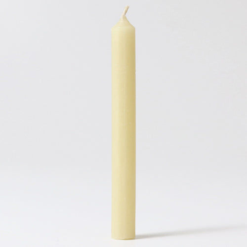 Een enkel crème bijenwaskaarsje staat rechtop.