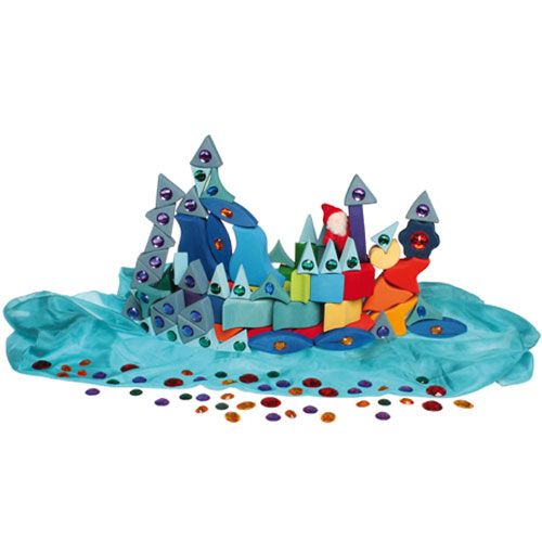 Een fantasielandschap van houten blokken en een blauwe doek, versierd met grimm's kleurrijke acryl diamanten en een kabouterfiguur.