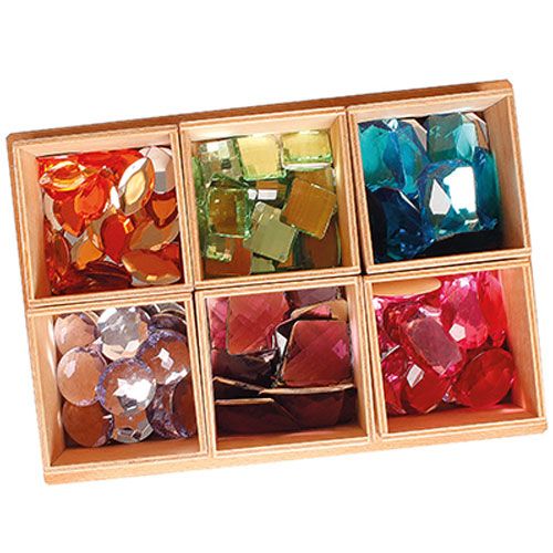Een houten sorteerbak met zes vakken, elk gevuld met veelkleurige grimm's speelgoed diamanten.