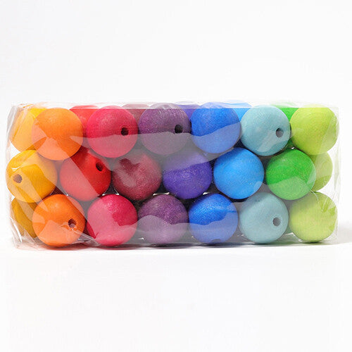 Verpakking van grimm's houten kralen in regenboogkleuren, strak naast elkaar gerangschikt.