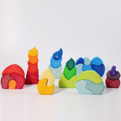 Een collectie grimm's houten bakkershuisjes in verschillende kleuren, gestapeld en naast elkaar.