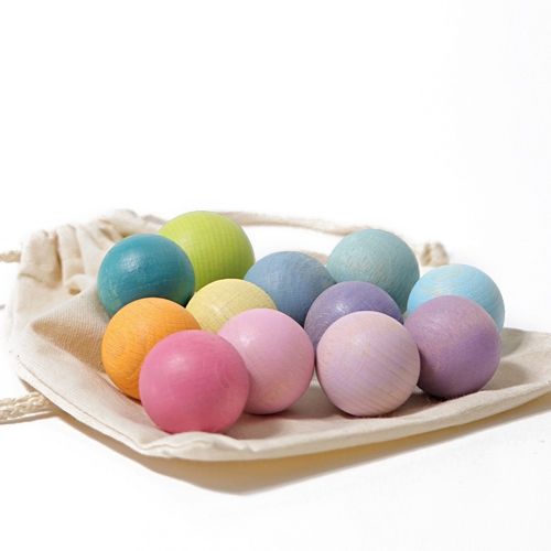Grimm's pastelkleurige houten ballen, 12 stuks, liggen op een stoffen zakje.