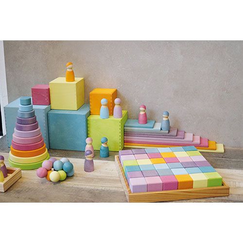 Een demonstratie van Grimm's houten bouwspeelgoed in pastelkleuren, waaronder stapelblokken, ringen en mozaïekblokjes.