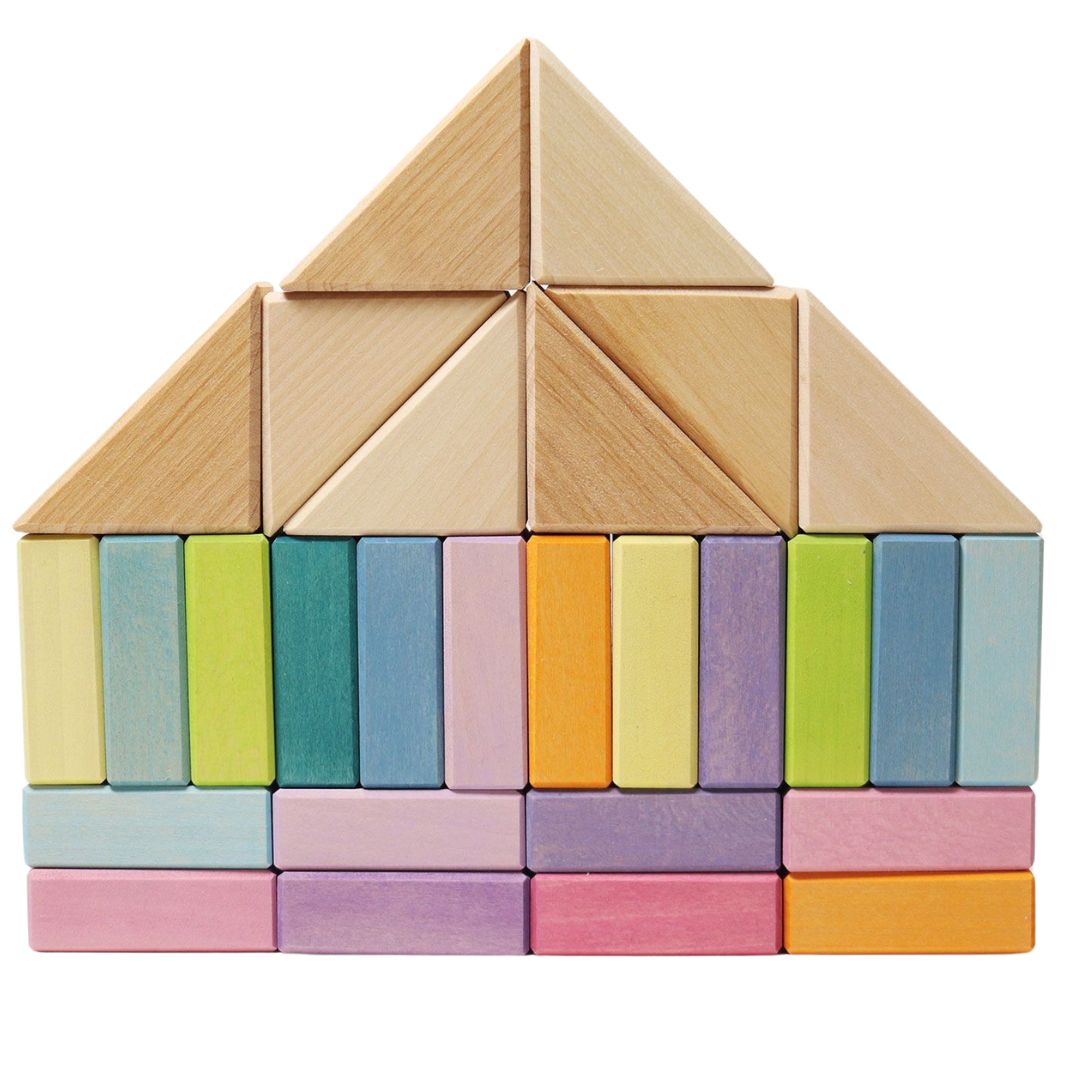 Een huis gebouwd van grimm's houten bouwblokken, met een basis van pastelkleurige rechthoekige blokken en een dak van natuurlijke driehoekige blokken.