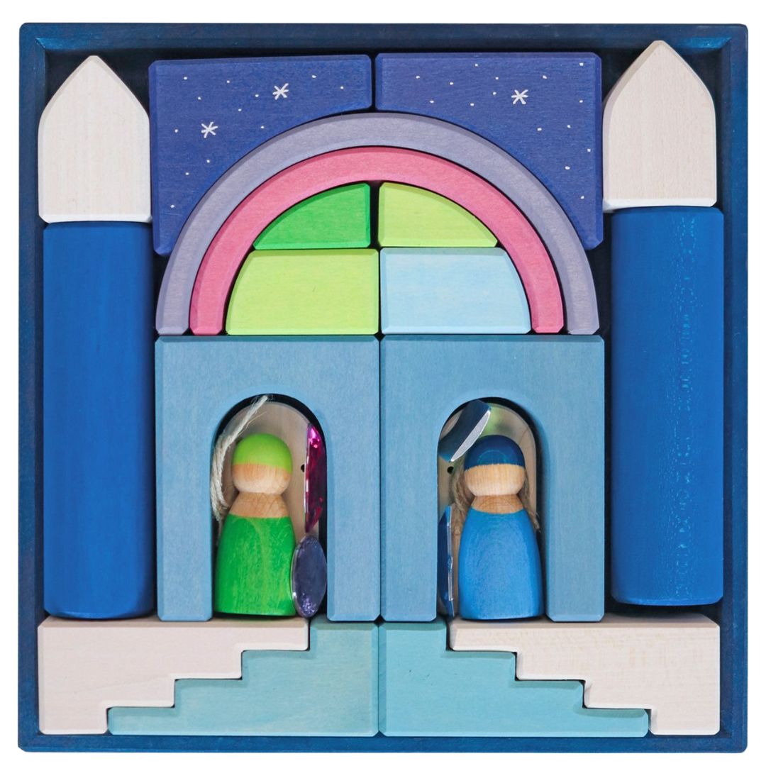 Grimm's houten bouwblokken poollicht in een blauwe doos, opgebouwd tot een gebouw met twee poppetjes.