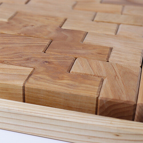 Detail van Grimm's houten bouwblokken in een bak, met zicht op de houtnerf en in elkaar passende vormen.