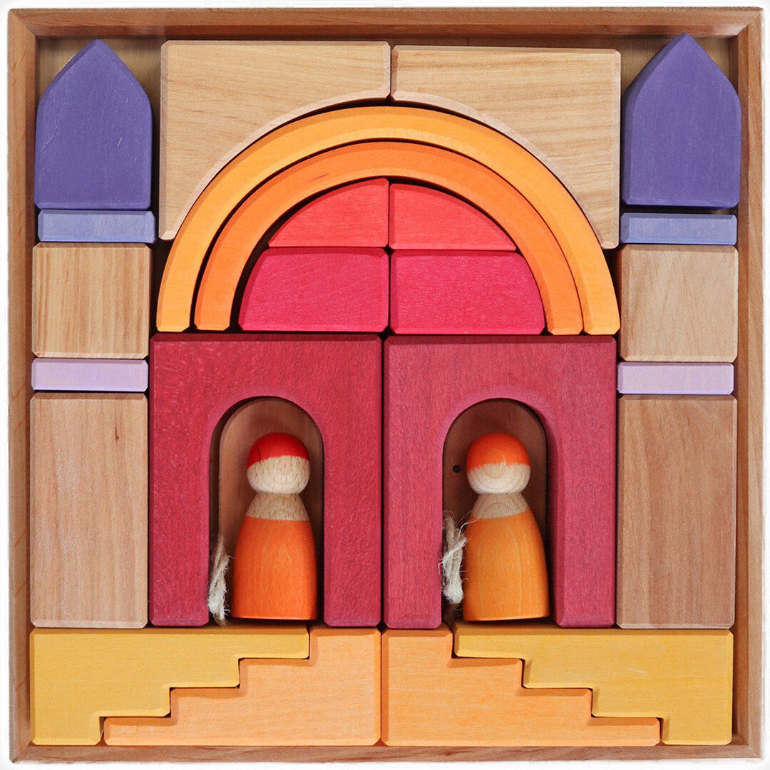 Grimm's houten bouwblokken set in een houten kist, opgebouwd als een kasteel met twee poppetjes.