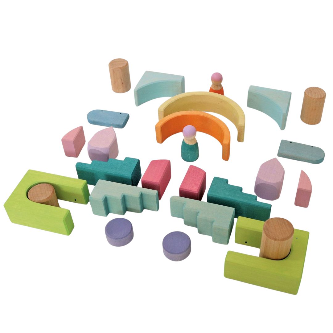 Een overzicht van alle 26 Grimm's houten bouwblokken wolkenspel in diverse pastelkleuren en vormen, inclusief twee poppetjes.