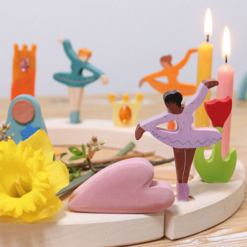 Grimm's houten decoratie figuur van een paarse ballerina op een houten verjaardagskring met andere figuren en kaarsen.