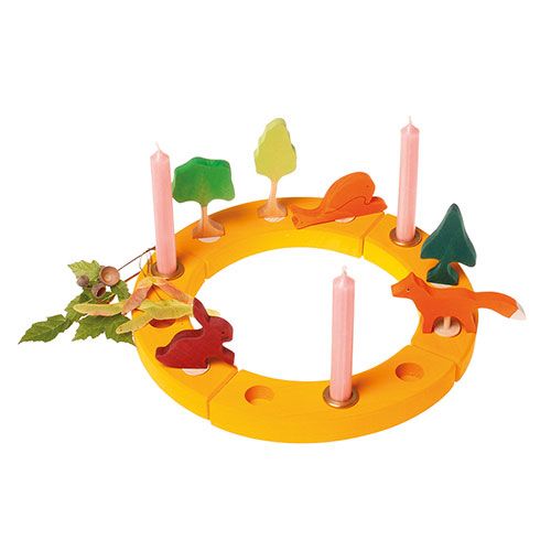 Houten decoratiering met roze kaarsen en diverse houten natuurfiguren zoals een boom, vos en konijn.