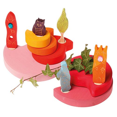 Een collectie grimm's houten decoratie figuren met roze platforms, een uil, een boom en bladhuisjes, versierd met een klimoprank.
