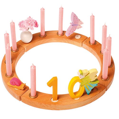 grimm's houten verjaardagsring gedecoreerd met kaarsen, bloemen en de cijfers 1 en 0.