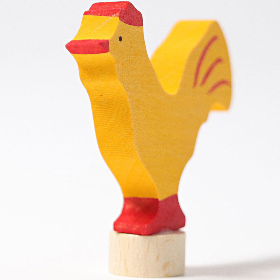 grimm's houten decoratiefiguur van een gele haan, schuin van voren gefotografeerd.