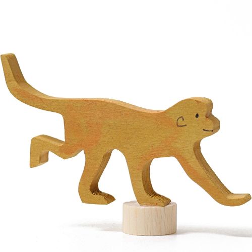 Grimm's houten decoratiefiguur van een gele lopende aap, balancerend op een houten voetstuk.