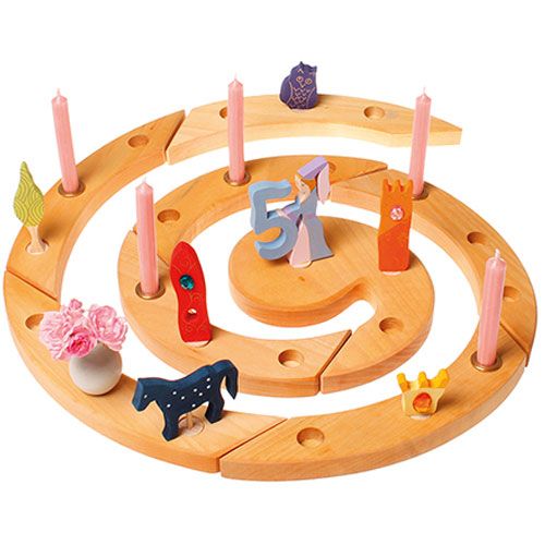 Een houten spiraalvormige verjaardagsring met diverse Grimm's houten decoratiefiguren, waaronder het blauwe paard, kaarsen en andere thema-items.