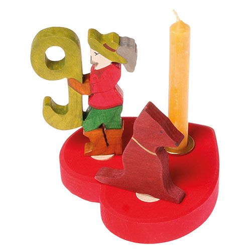 Grimm's rode houten decoratiefiguur van een hond op een hartvormige basis met een jongen, het cijfer 9 en een kaars.