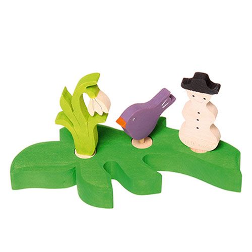 Grimm's houten decoratiefiguren van een sneeuwklokje, een paarse vogel en een sneeuwpop op een groene basis.