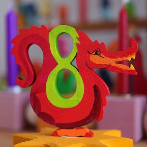 Grimm's houten decoratiefiguur van een rode draak met het groene cijfer 8, staand op een gele ster.