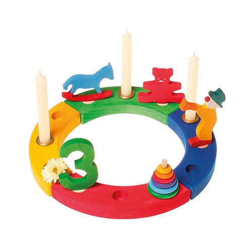Grimm's houten verjaardagsring met diverse decoratiefiguren, waaronder een kleine stapeltoren, paard, beer en clown.