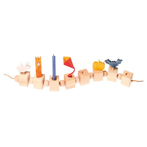 Collectie houten decoratiefiguren met een blauwe vleermuis, pompoen en vlieger op een rij.