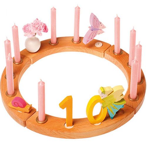 grimm's houten verjaardagsring met roze kaarsen, een vlinder, een slak en het cijfer 10.