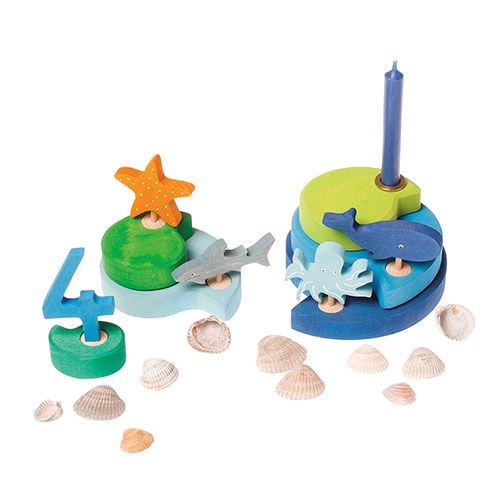 Twee houten verjaardagsringen met zee-thema decoraties, waaronder een oranje zeester, een haai, een octopus en een walvis.