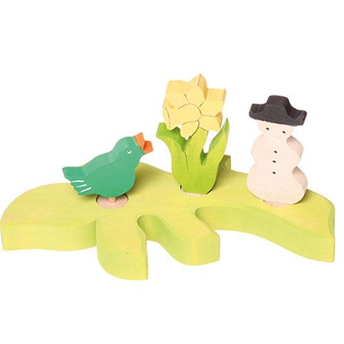 grimm's houten decoratie figuren van een zingende vogel, een gele bloem en een sneeuwpop op een groene basis.