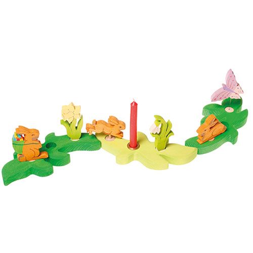 Grimm's houten Paasdecoratie set met haasjes, bloemen, een vlinder en een kaars op een groene basis.