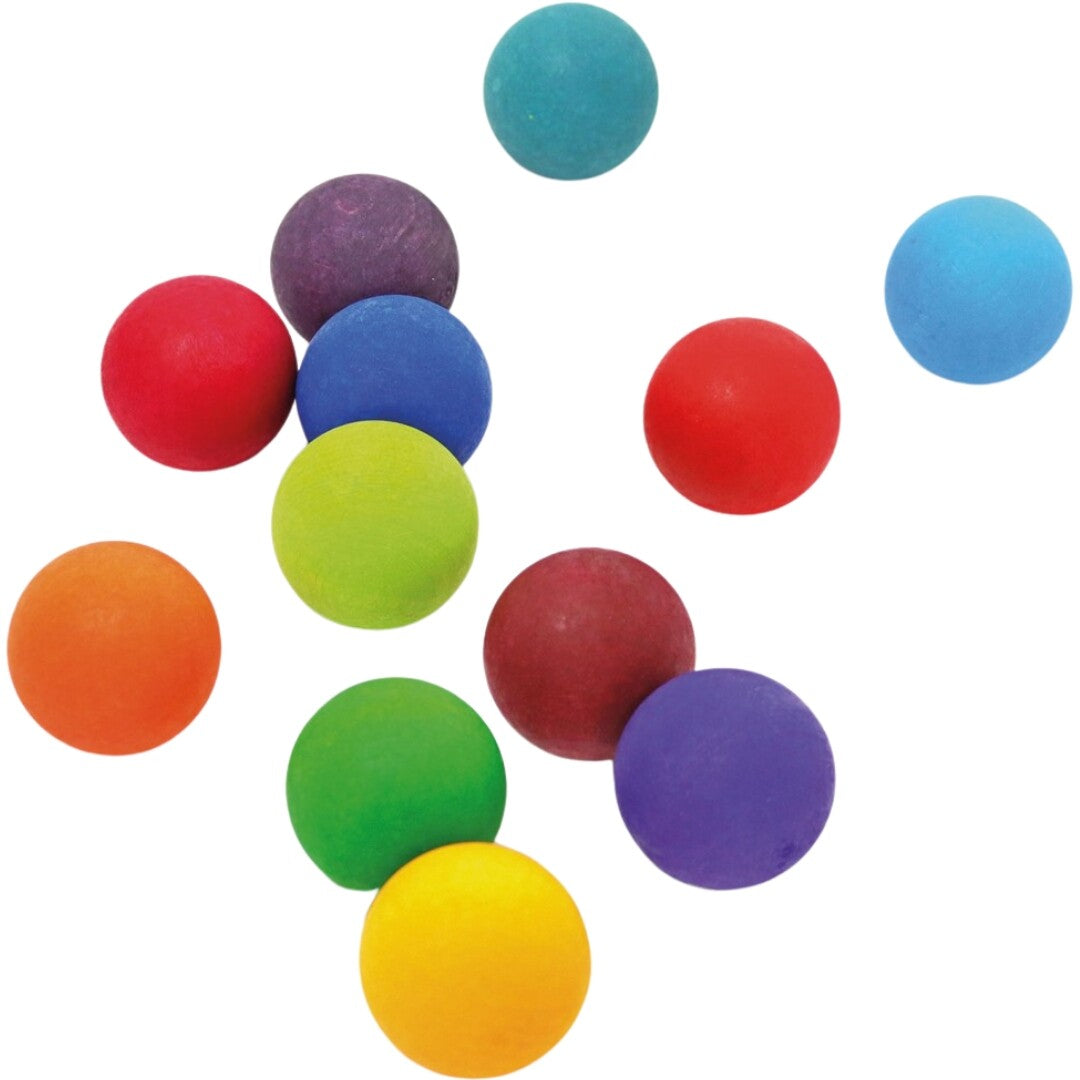 grimm's houten ballen in regenboogkleuren verspreid over een witte achtergrond.