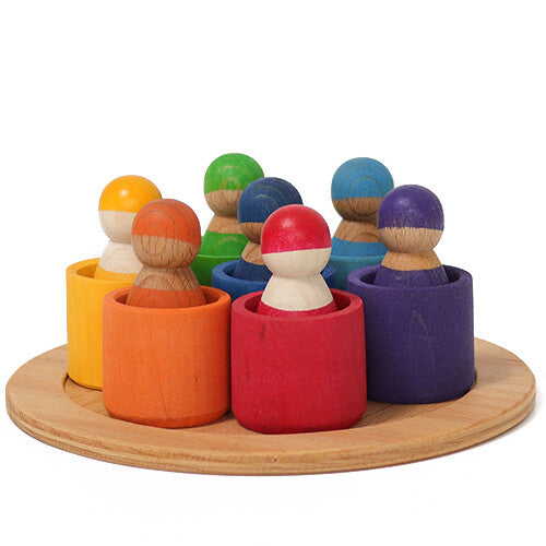 grimm's houten regenboog vrienden in gekleurde kommen op een ronde houten schijf.