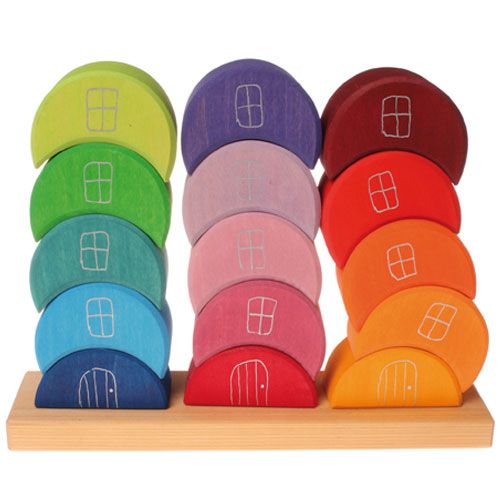 grimm's houten stapel maanhuisjes in drie regenboogkleurige stapels op een houten plank.