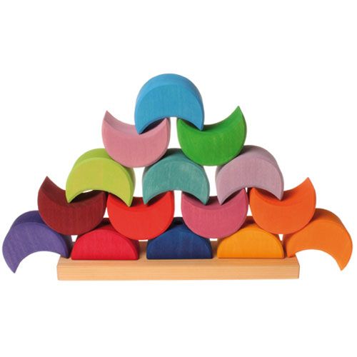 grimm's houten stapel maanhuisjes in verschillende kleuren gestapeld op een houten plank.
