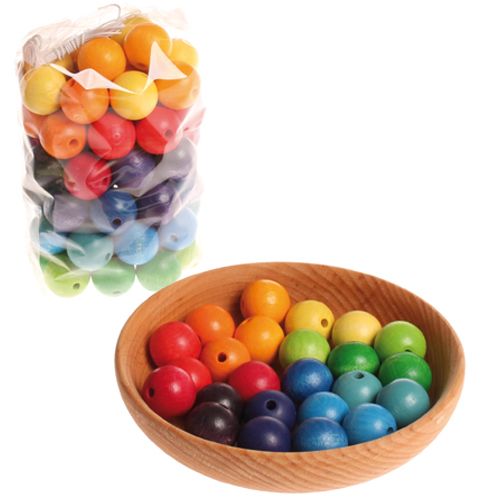 Grimm's houten regenboogkralen in een zak en gesorteerd in een houten kom.