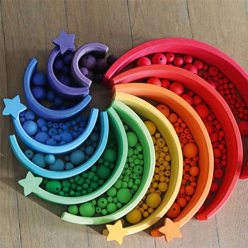 Grimm's houten regenboogkralen gesorteerd in houten regenboogbogen met sterren.