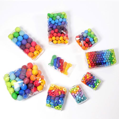 Collectie van grimm's houten regenboogkralen in verschillende transparante verpakkingen.