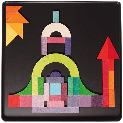 Grimm's houten magneetpuzzel die een kleurrijk gebouw of landschap met een zon vormt met diverse geometrische houten blokken op een zwarte ondergrond.