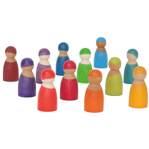Twaalf grimm's houten peg dolls in regenboogkleuren staan verspreid op een witte ondergrond.