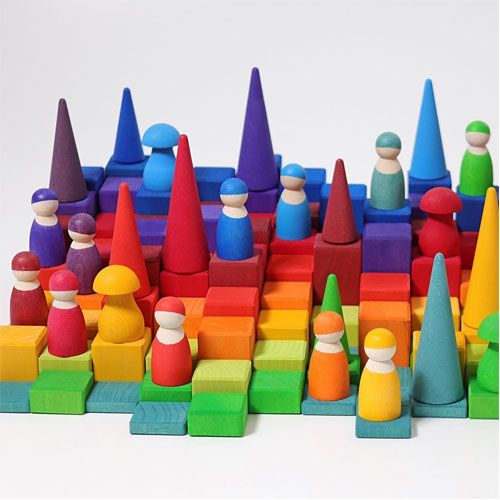 Een kleurrijk landschap van grimm's houten blokken, kegels en peg dolls in regenboogkleuren.