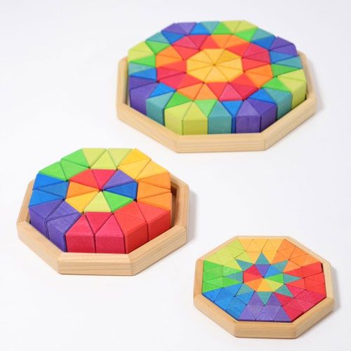 Drie Grimm's achthoekige houten puzzels met veelkleurige driehoekige stukjes, van bovenaf gezien.