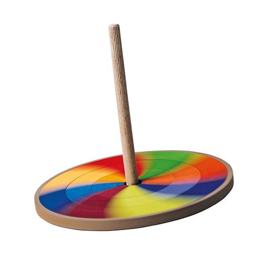 Grimm's houten tol met regenboogpatroon draait, waardoor de kleuren in elkaar overlopen.