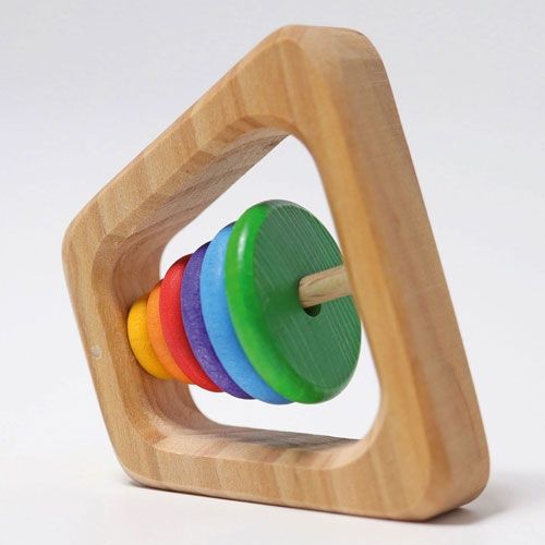 Grimm's houten rammelaar-bijtring in piramidevorm met regenboogkleurige stapelringen, schuin gefotografeerd.