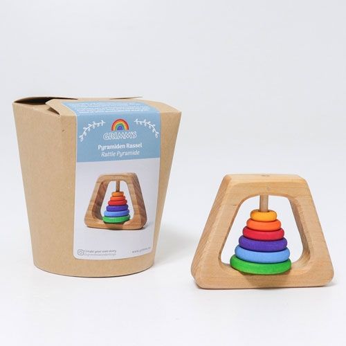 Grimm's houten rammelaar-bijtring naast de bruine productverpakking.