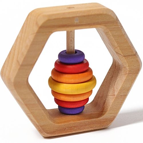Grimm's houten zeshoekige rammelaar met regenboogkleurige ringen, schuin gefotografeerd.
